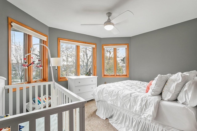 carpeted bedroom with multiple windows and ceiling fan