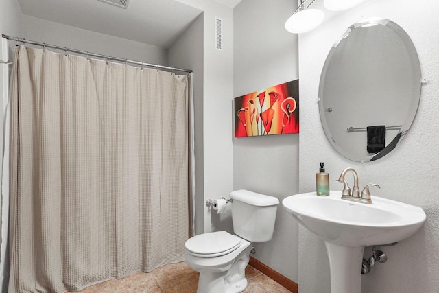 bathroom featuring toilet, tile patterned floors, sink, and a shower with curtain