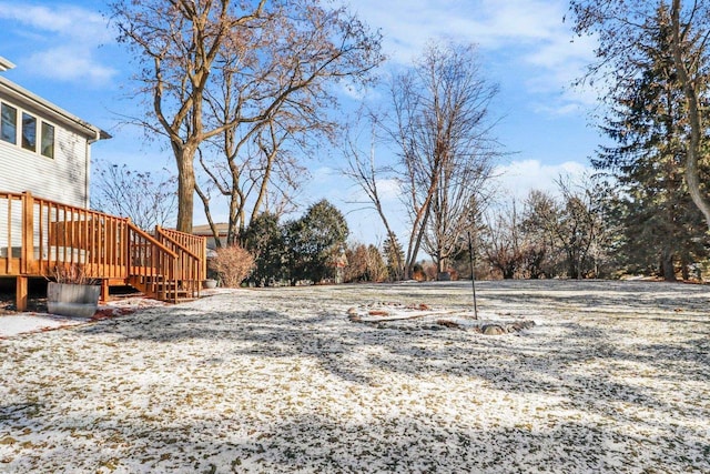 yard covered in snow with a deck