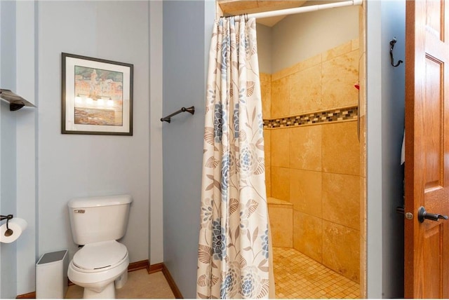 full bath with toilet, a stall shower, and baseboards