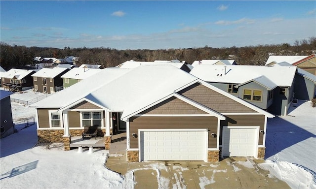 view of front of property featuring an attached garage, stone siding, and a residential view