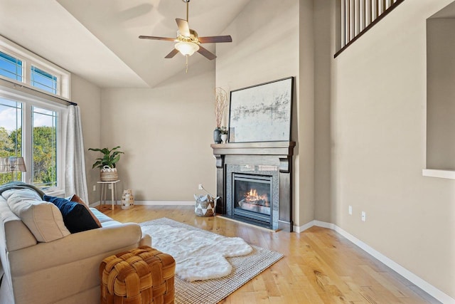 living room featuring light hardwood / wood-style floors, ceiling fan, and vaulted ceiling