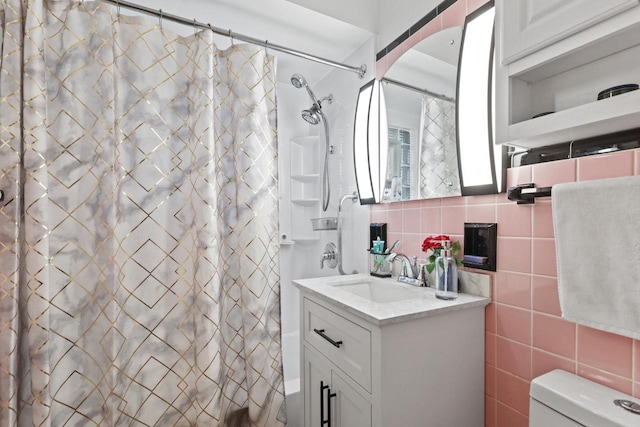 bathroom with tile walls, backsplash, vanity, and toilet