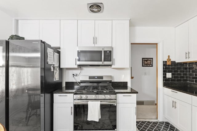 kitchen featuring white cabinets, dark stone counters, and appliances with stainless steel finishes