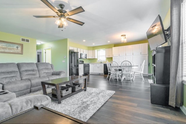 living room with ceiling fan, sink, and dark hardwood / wood-style floors