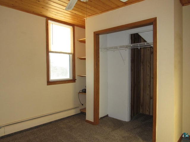 unfurnished bedroom featuring a closet, wood ceiling, a baseboard heating unit, ceiling fan, and dark carpet