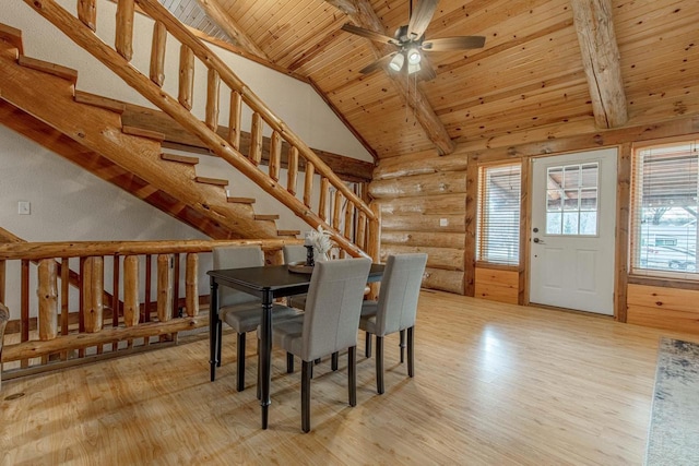 unfurnished dining area with rustic walls, light wood-type flooring, wooden ceiling, ceiling fan, and beamed ceiling