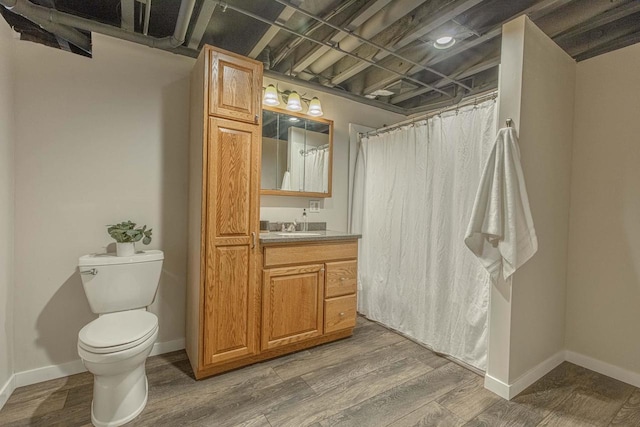 bathroom with toilet, hardwood / wood-style flooring, curtained shower, and vanity