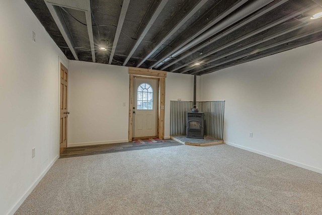 interior space featuring carpet and a wood stove