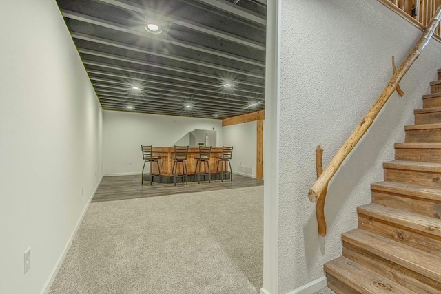 stairway with bar area and carpet