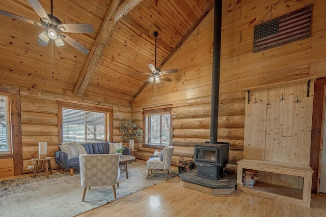 unfurnished living room featuring hardwood / wood-style flooring, wood ceiling, a wood stove, high vaulted ceiling, and beamed ceiling