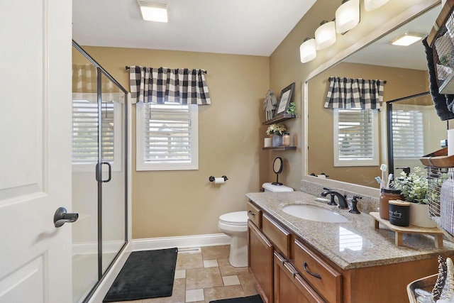 bathroom featuring toilet, walk in shower, a healthy amount of sunlight, and vanity