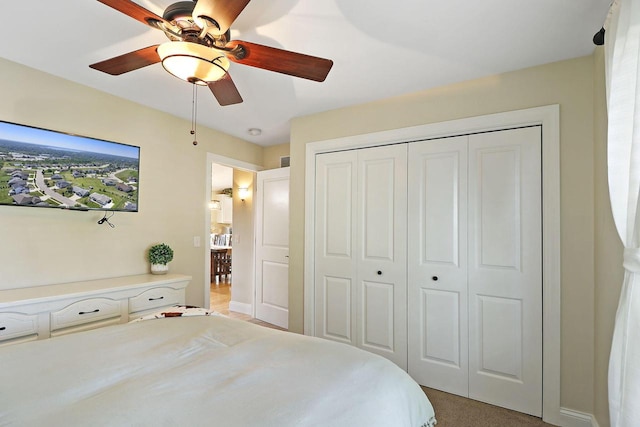 carpeted bedroom with ceiling fan and a closet