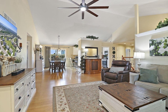 living room with high vaulted ceiling, ceiling fan, and light hardwood / wood-style flooring