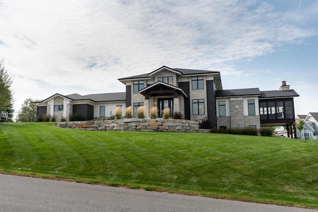 view of front facade with a front lawn and a sunroom