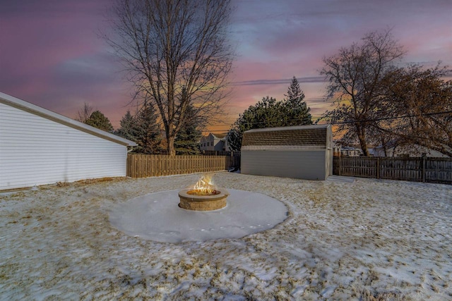 yard at dusk with a fire pit and a shed