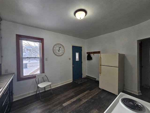 kitchen with stove, dark wood-type flooring, and white refrigerator