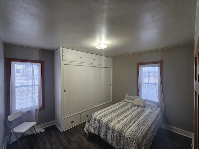 bedroom featuring dark hardwood / wood-style flooring, a closet, and a textured ceiling