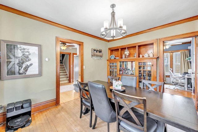 dining space featuring light hardwood / wood-style floors, an inviting chandelier, and crown molding