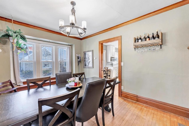 dining space with an inviting chandelier, ornamental molding, and hardwood / wood-style flooring