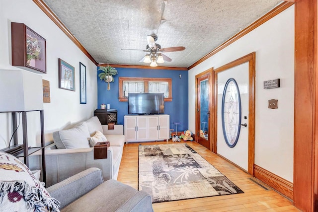 living room with light wood-type flooring, ceiling fan, and ornamental molding