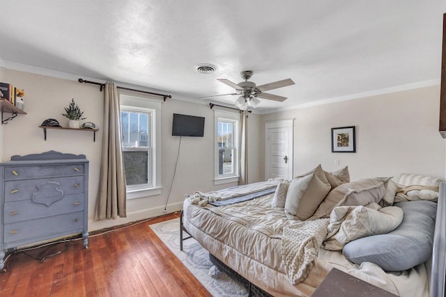 bedroom featuring ceiling fan, crown molding, and dark wood-type flooring