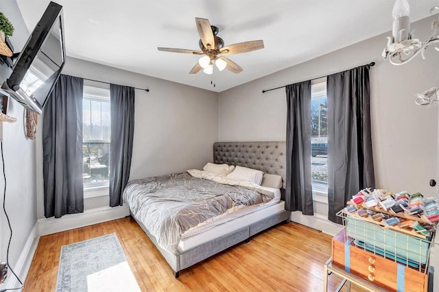 bedroom with hardwood / wood-style floors, multiple windows, and ceiling fan