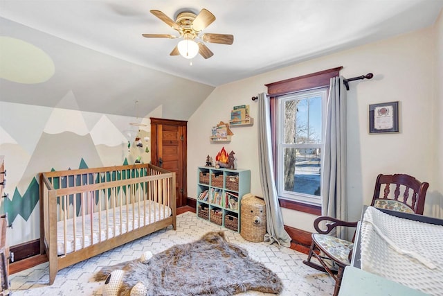 bedroom featuring lofted ceiling, a crib, and ceiling fan