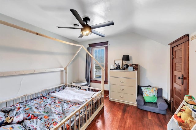 bedroom with ceiling fan, vaulted ceiling, and dark hardwood / wood-style floors