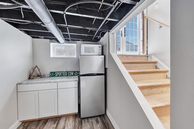 kitchen featuring dark hardwood / wood-style flooring, white cabinetry, stainless steel refrigerator, and plenty of natural light