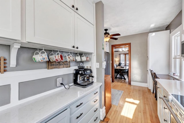 kitchen featuring white cabinets, ceiling fan, and light hardwood / wood-style floors