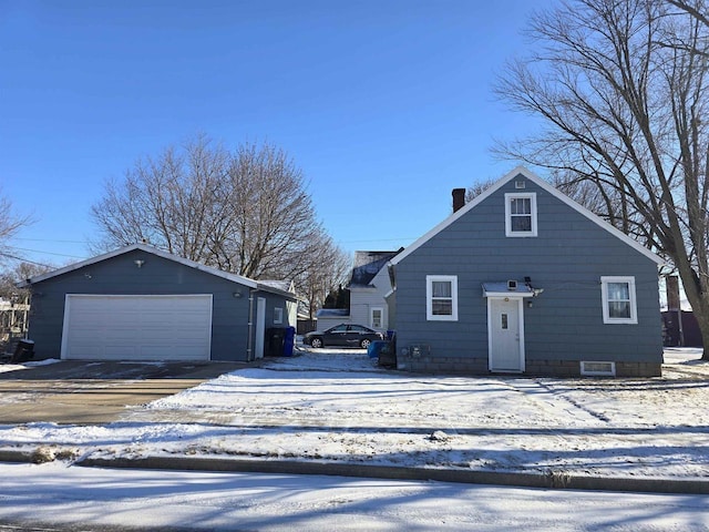 view of front of house featuring a garage and an outbuilding