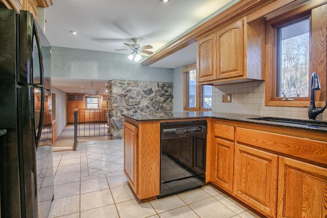 kitchen with light tile patterned floors, ceiling fan, black appliances, and dark stone countertops