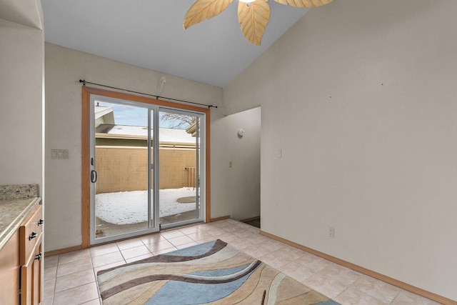 doorway featuring lofted ceiling, ceiling fan, and light tile patterned floors