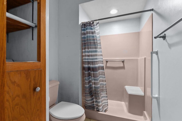 bathroom featuring toilet and a shower with shower curtain