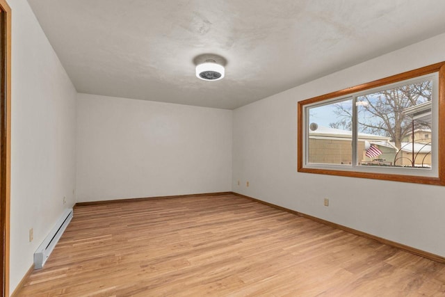 spare room with light hardwood / wood-style floors and baseboard heating