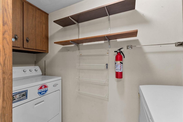 clothes washing area with cabinets