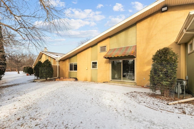 snow covered house with central air condition unit