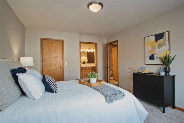 bedroom featuring ensuite bath and light colored carpet