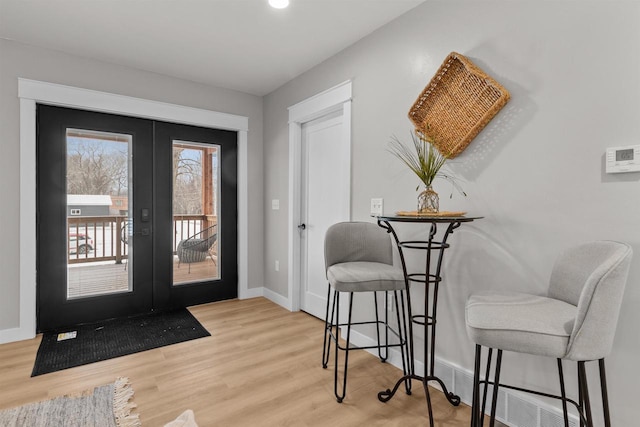 foyer entrance with light hardwood / wood-style floors and french doors