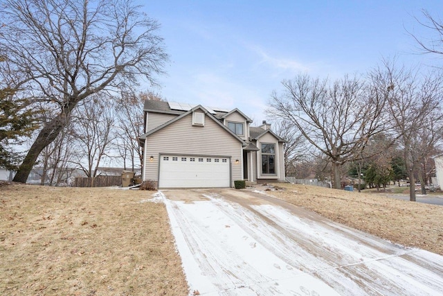 view of front property with a garage and solar panels