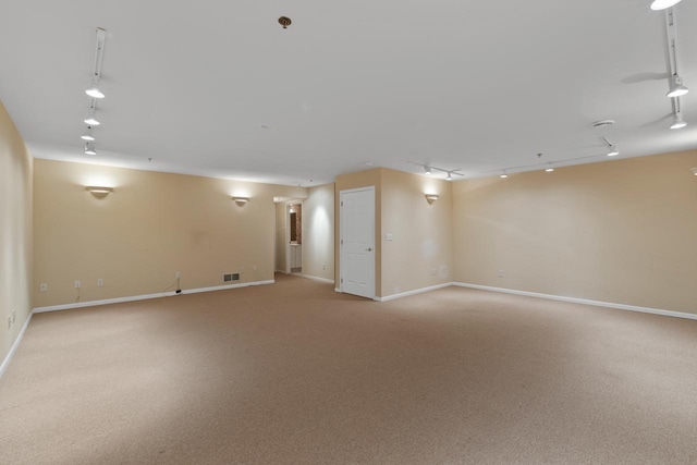 carpeted spare room with rail lighting