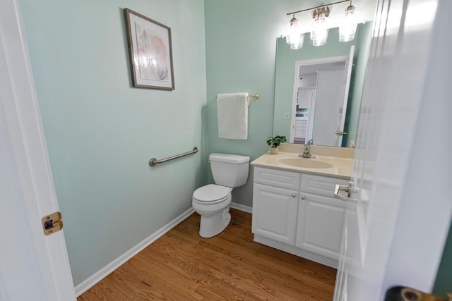 bathroom featuring toilet, hardwood / wood-style flooring, and vanity