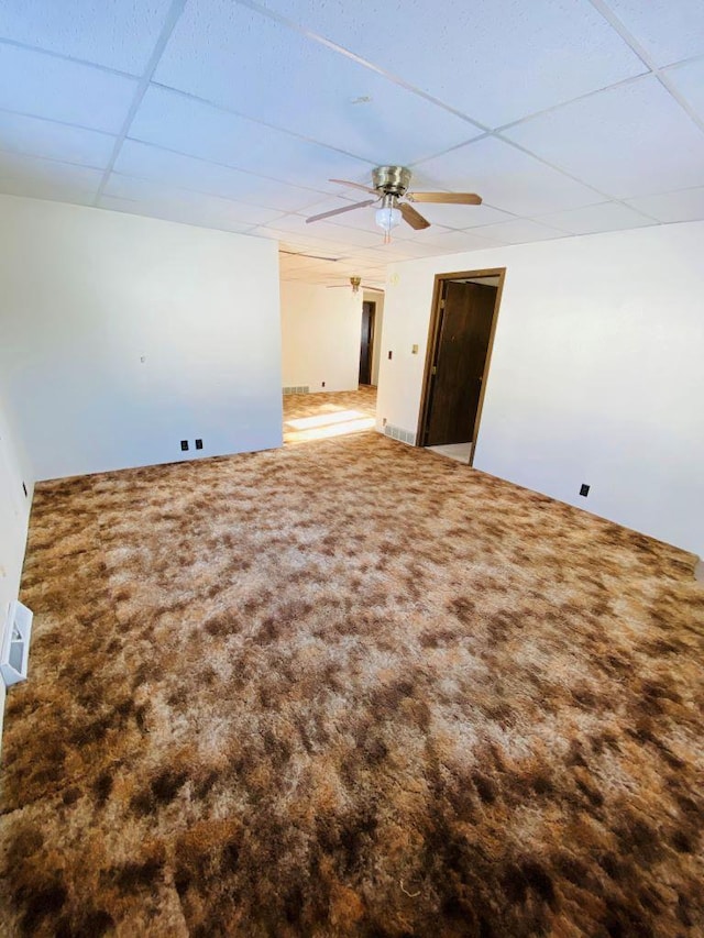 spare room featuring carpet flooring, ceiling fan, and a paneled ceiling