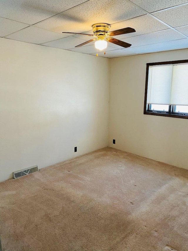 unfurnished room with ceiling fan, carpet, and a drop ceiling