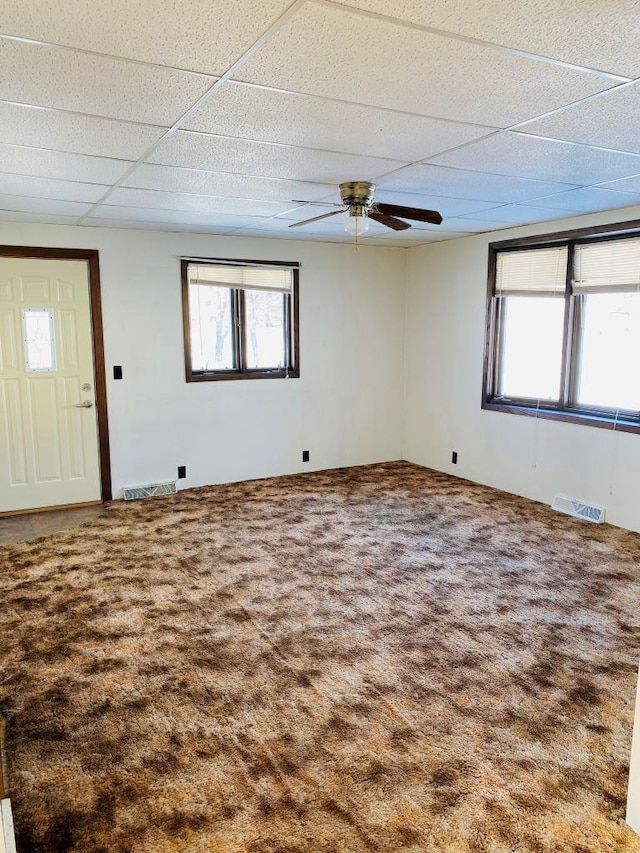 carpeted spare room featuring ceiling fan and a paneled ceiling