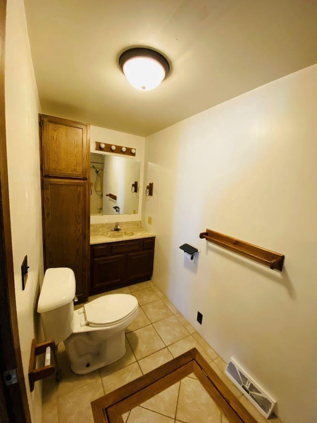 bathroom with toilet, tile patterned floors, and vanity