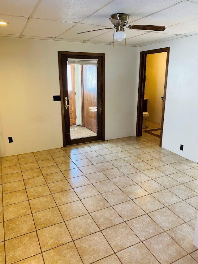 unfurnished room featuring ceiling fan, a paneled ceiling, and light tile patterned floors