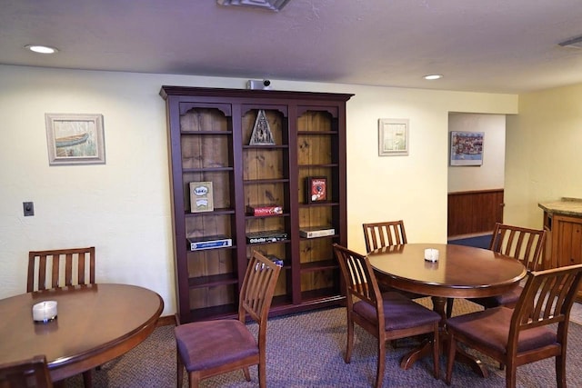 dining room featuring dark carpet