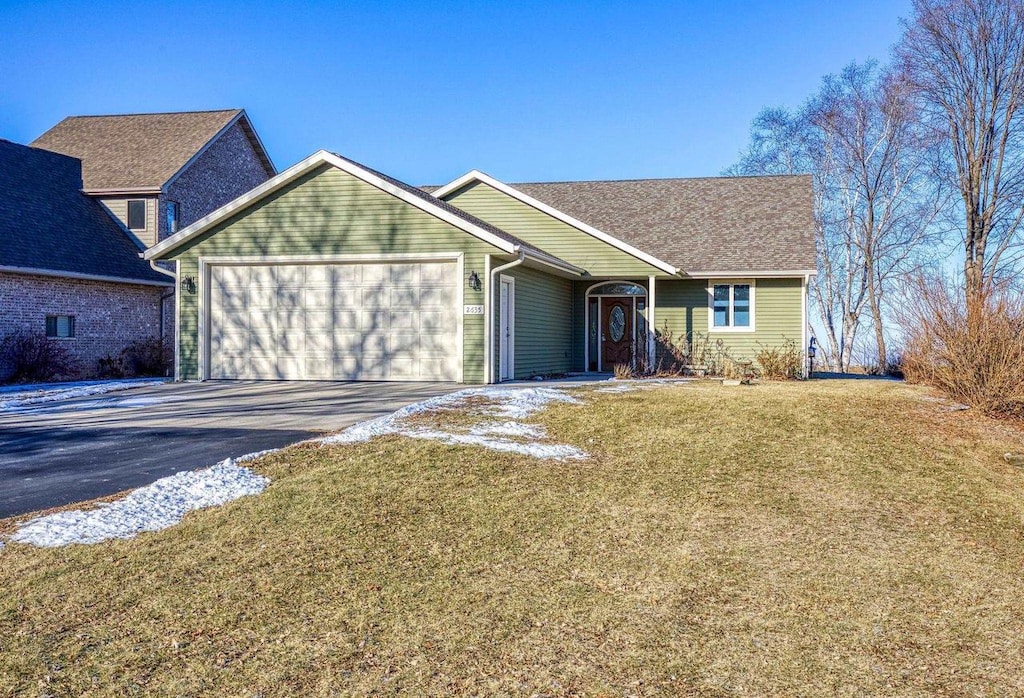 view of front of property with a front yard and a garage